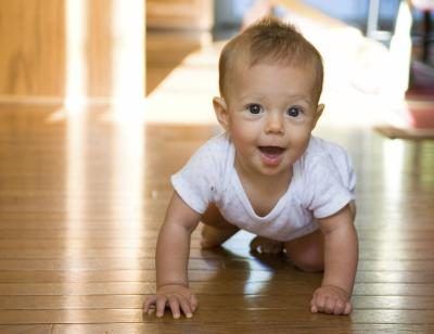 Jeune bébé ramper sur le plancher de bois.