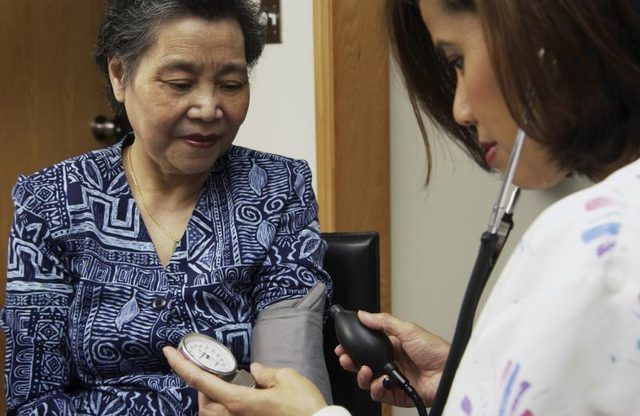 Vérifier femme d'âge mûr infirmière's blood pressure.