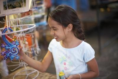 Jeune fille regardant jouet coloré en magasin.