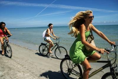 Amis roulent leurs vélos sur la plage.