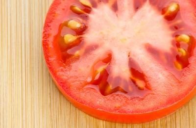 Smash une tomate mûrie sur une plaque puis égoutter les jus de fruits.