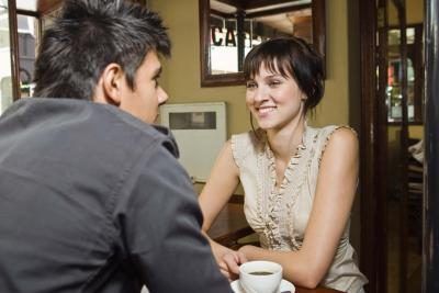 Une femme sourit à une table dans un café.
