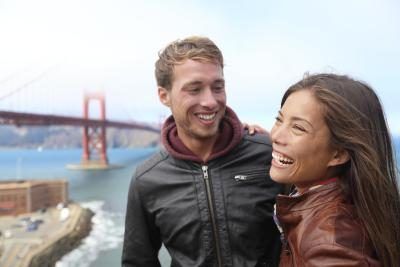 Un homme et une femme rire ensemble dans un endroit pittoresque par l'eau.