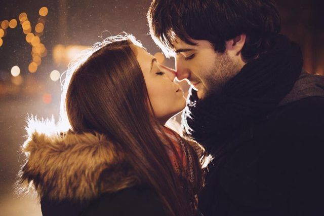 Un jeune couple sur le point d'embrasser la nuit.