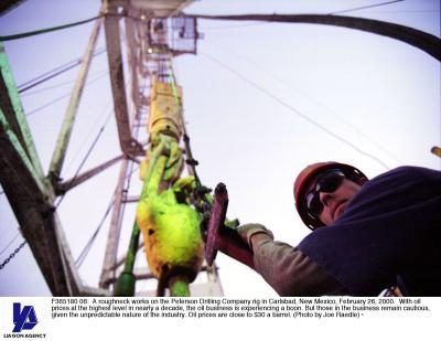 Un travailleur de la plate-forme pétrolière au Texas regarde vers le bas d'une tour.